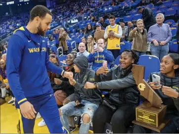  ?? KARL MONDON — STAFF PHOTOGRAPH­ER ?? Steph Curry greets the Division I state champion Oakland Tech girls basketball team at Chase Center before the start of the Warriors game against the San Antonio Spurs on Friday night.