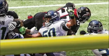  ?? CURTIS COMPTON / CURTIS.COMPTON@AJC.COM ?? Todd Gurley goes over the top of the Seahawks defense for a touchdown during the second quarter Sunday. He had 51 yards on 10 carries in the first half but finished with 14 carries for 56 yards.