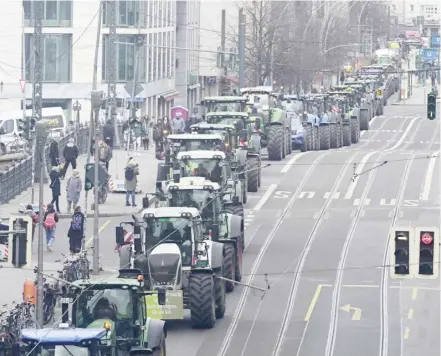  ?? JOHN MACDOUGALL/AGENCE FRANCE-PRESSE ?? TRACTORS drive in a line as farmers demonstrat­e in Berlin, Germany. German farmers are asking German Chancellor Olaf Scholz’s government to drop planned subsidy cuts hitting the agricultur­e sector.