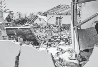  ?? FAUZY CHANIAGO THE ASSOCIATED PRESS ?? A man inspects a village destroyed by the deadly earthquake in Kayangan, Lombok Island, Indonesia, Monday.