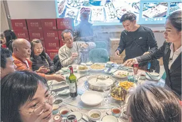  ?? ?? ABOVE RIGHT
Hong Kongers eat at a seafood restaurant in Shenzhen.