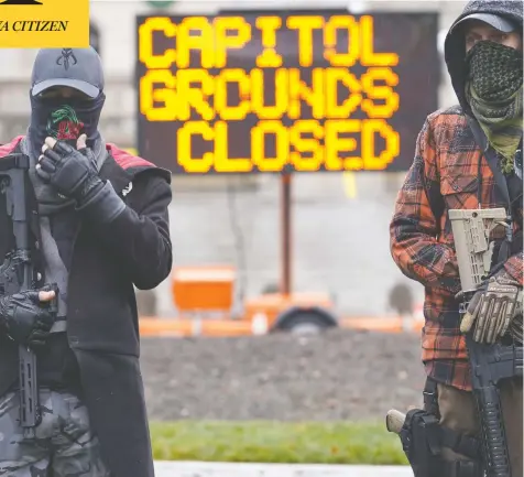  ?? BRYAN WOOLSTON / AP PHOTO ?? Armed protesters stand outside the Capitol building in Frankfort, Ky., on Sunday. Rallies planned at state capitols drew relatively small numbers.