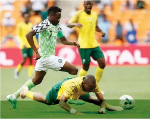  ??  ?? South Africa’s Tiyani Mabunda (down) tumbles under pressure from Super Eagles’ captain Ahmed Musa (left) during the 2019 Africa Cup of Nations Group E qualifier at FNB Stadium