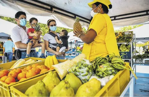  ?? Mery granados ?? Juan y Alejandra, con sus pequeños hijos, compraron algunas frutas y verduras en el puesto de Mónica.