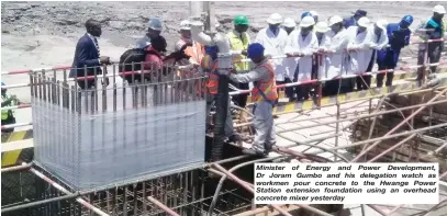  ??  ?? Minister of Energy and Power Developmen­t, Dr Joram Gumbo and his delegation watch as workmen pour concrete to the Hwange Power Station extension foundation using an overhead concrete mixer yesterday