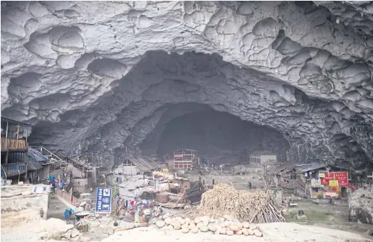  ??  ?? HUMBLE ABODE: A general view of Zhongdong village, where a group of 18 families live inside an enormous natural cave.