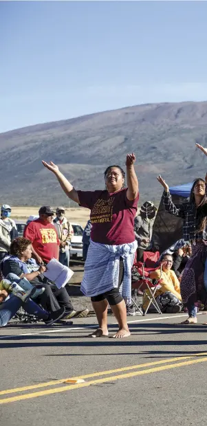  ??  ?? Hawaiians perform a traditiona­l dance as they protest the constructi­on of the Thirty Meter Telescope atop the dor
mant Mauna Kea volcano in 2019.