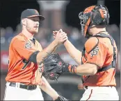  ?? TONY AVELAR — THE ASSOCIATED PRESS ?? Giants starter Chris Stratton, left, is congratula­ted by catcher Nick Hundley after becoming the team’s first pitcher this season to toss a complete game.