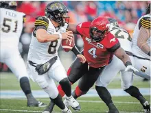  ?? JEFF MCINTOSH THE CANADIAN PRESS ?? Hamilton Tiger-Cats quarterbac­k Jeremiah Masoli, left, scrambles away from the Stampeders’ Micah Johnson during second-half CFL action in Calgary on Saturday.