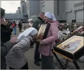  ?? ALEXANDER ZEMLIANICH­ENKO — THE ASSOCIATED PRESS ?? Orthodox believers attend a service at a makeshift memorial in front of the Crocus City Hall on the western outskirts of Moscow on Tuesday.