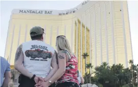  ?? Picture:AFP ?? SCENE OF CARNAGE. A couple look at the two broken windows in the Mandalay Bay hotel from which gunfire was directed.