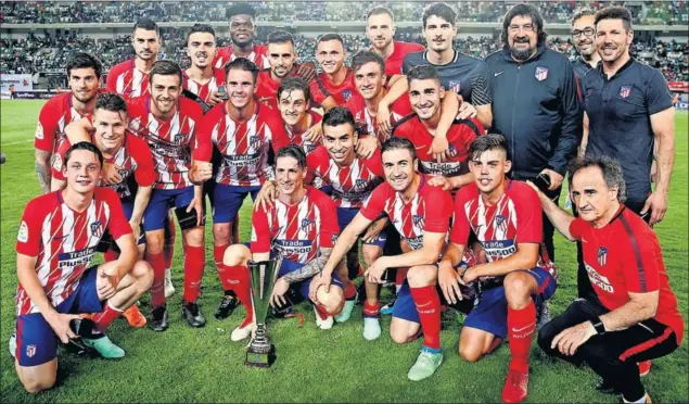  ??  ?? COPA DE DESPEDIDA. El Atlético despidió la temporada con una victoria en el amistoso en Nigeria. Fue ya sí el adiós de Torres, en la foto con el trofeo, y otro gesto de cariño de Gabi.