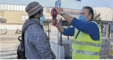  ?? Elisenda Pons ?? Toma de temperatur­a a un trabajador en el acceso a un matadero de Vic, el año pasado.