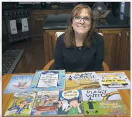  ?? STAFF PHOTOS BY MICHAEL REID ?? Tall Timbers author Liz Cooper poses with her eight books, three of which were recently printed in braille to distribute to blind children across the country.