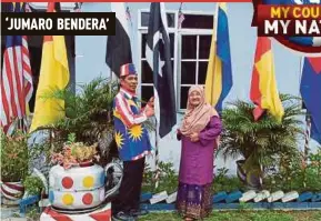  ?? PIC BY ABNOR
HAMIZAM ABD MANAP ?? Mohd Jumaro Marzuki and his wife, Azizah Yakimin, with their flag collection at their house in Felda Raja Alias 4 in Jempol.