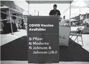  ?? MARIO TAMA/GETTY ?? A sign displays the types of COVID-19 vaccinatio­n doses available at a Walgreens mobile bus clinic Friday in Los Angeles.