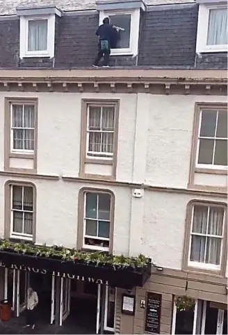  ??  ?? Risky business: Window cleaner out on a limb as bystander appears oblivious