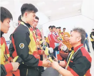  ??  ?? TAHNIAH: Atlet skuasy menerima maskot SUKMA XIX Perak 2018 daripada Snowdan setelah memenangi pingat perak semalam.