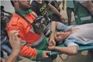  ??  ?? Palestinia­n medics evacuate a wounded youth from Friday’s protest.