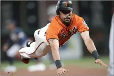  ?? THEARON W. HENDERSON — GETTY IMAGES ?? The Giants’ LaMonte Wade Jr. dives into third base safely against the Braves in the bottom of the sixth inning at Oracle Park on Friday in San Francisco.