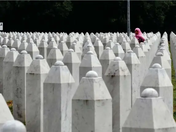  ?? (AFP/Getty) ?? A Bosnian Muslim walks among tombstones at Potocari