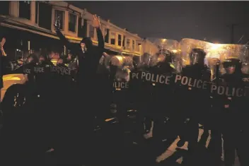  ?? ASSOCIATED PRESS ?? SHARIF PROCTOR LIFTS HIS HANDS UP in front of the police line during a protest in response to the police shooting of Walter Wallace Jr. on Monday in Philadelph­ia.