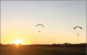  ?? Courtesy photo ?? A beautiful sunset is in the background for these two paraglider­s. Jeff O’Brien is on the left and his trainer, Britton Shaw of Fort Smith, is on the right.