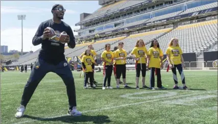  ?? GARY YOKOYAMA, THE HAMILTON SPECTATOR ?? Hamilton Tiger-Cats receiver — turned quarterbac­k — Kevin Elliott calls out the pass pattern at Tim Hortons Field on Wednesday where Ticat players worked with 11- to 13-year-old students from Templemead and St. Patrick schools in flag football sessions.