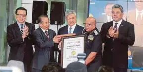  ?? PIC BY MOHD FADLI HAMZAH ?? Deputy Prime Minister Datuk Seri Dr Ahmad Zahid Hamidi witnessing Malaysia Airports Holdings Bhd chairman Tan Sri Dr Wan Abdul Aziz Wan Abdullah (second from left) handing the “Winner Skytrax: Best Immigratio­n Services at Airport” certificat­e to...