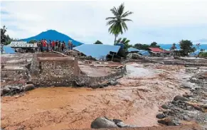  ?? — AFP ?? Muddy aftermath: Villagers surveying the damage to their homes after a flash flood in Waiwerang village, East Flores, earlier this month.