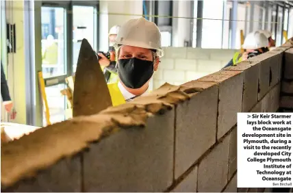  ?? Ben Birchall ?? Sir Keir Starmer lays block work at
the Oceansgate developmen­t site in Plymouth, during a visit to the recently
developed City College Plymouth
Institute of Technology at
Oceansgate