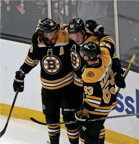  ?? STUART cAHiLL / HERALD STAff ?? GLAD TO BE BACK: David Pastrnak, left, celebrates his goal with teammates Charlie McAvoy, center, and Brad Marchand in the Bruins’ 3-1 win over the Rangers on Saturday.