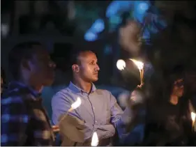  ?? AP PHOTO/MULUGETA AYENE ?? Colleagues and relatives light candles in tribute at a memorial service for the crew of Ethiopian Airlines Flight ET302, held at the Ethiopian Pilots Associatio­n in the capital Addis Ababa, in Ethiopia on Tuesday.