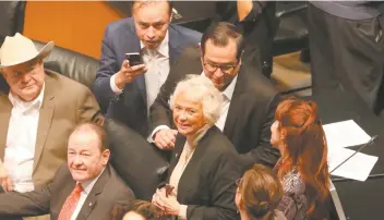  ??  ?? Olga Sánchez Cordero, ex ministra de la Suprema Corte (centro), al salir de la sesión en la que solicitó licencia para ocupar el cargo de secretaria de Gobernació­n en el gobierno de Andrés Manuel López Obrador.
