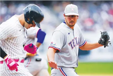  ?? Associated Press ?? ■ Texas Rangers starting pitcher Dane Dunning, right, gets an out by stepping on first base Sunday during the sixth inning of the first game of a baseball double-header against the New York Yankees at Yankee Stadium in New York.