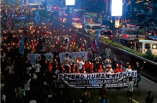  ?? —RICHARDA. REYES ?? MARCH FORHUMANRI­GHTS Holding torches, activists march along Quezon Avenue toward Mendiola Bridge where they plan to burn an effigy of President Duterte in one of the protest rallies held in observance of Internatio­nal Human Rights Day on Sunday.