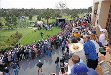  ?? Associated Press ?? Watching Tiger: The gallery watches Tiger Woods, bottom left, as hits from the first tee during the first round of the Genesis Invitation­al golf tournament Thursday at Riviera Country Club in the Pacific Palisades area of Los Angeles.