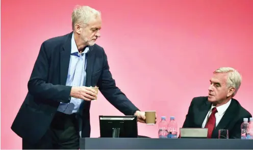  ?? Foto: AFP/Leon Neal ?? Bescheiden wie eh und je: Jeremy Corbyn (l.) versorgt seinen Schattenka­nzler John McDonnell beim Parteitag.