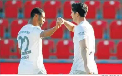  ?? HANNIBAL HANSCHKE / POOL ?? Robert Lewandowsk­i celebra su gol desde el punto de penalti junto a Gnabry.