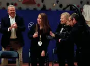  ?? ?? Abbey Kidwell, assistant principal at Clinton Elementary School, points to herself after it is revealed that she won the Milken Educator Award, along with $25,000, during an assembly in the gym in Clinton on March 28. Applauding her is Clinton Mayor Scott Burton, left, and 2001 winner Vicky Condalary.