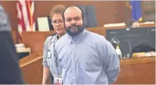  ?? MICHAEL SEARS / MILWAUKEE JOURNAL SENTINEL ?? Matthew Lee Wilks looks toward his family members in the gallery as he is led into the courtroom.