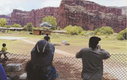  ?? AP PHOTOS ?? TOURISTS FORCED OUT: A helicopter lands on the Havasupai reservatio­n in Supai, Ariz., Thursday to help evacuate about 200 tourists caught in flash flooding at a washed-out campground, bottom, near the Grand Canyon where visitors go to see waterfalls,...