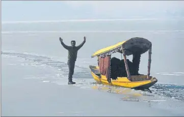  ?? WASEEM ANDRABI/HT ?? A boatman stands on the frozen Dal Lake in Srinagar on Wednesday.