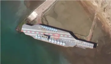  ?? (Maxar Technologi­es/via Reuters) ?? IRAN’S MOCK aircraft carrier, estimated at some 50%-70% the size of a real aircraft carrier, sits in Bandar Abbas Port earlier this year.