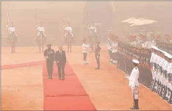  ?? [MANISH SWARUP/THE ASSOCIATED PRESS] ?? Enveloped in smog, Belgium’s King Philippe inspects a military honor guard at the Indian presidenti­al palace in New Delhi on Tuesday. The Belgian royal couple are on a seven-day state visit to India.