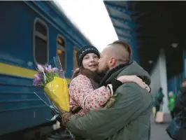  ?? ROMAN HRYTSYNA/AP ?? Ukrainian soldier Vasyl Khomko kisses his daughter Yana on Saturday at a train station in Kyiv. Yana and her mother have been living in Slovakia while the war rages on.