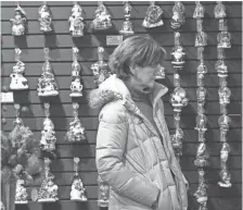  ??  ?? A shopper browses ornaments at Callisters Christmas at Mayfair mall.