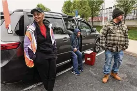  ?? ?? From left, Kaye White, Roger Clark and Chris Ortiz talk during a stop while making nightly rounds in the Connecticu­t Harm Reduction Alliance minivan in Hartford on April 28.