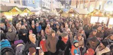  ?? FOTO: EICH ?? Warm eingepackt und in gemütliche­r Atmosphäre verfolgen die Besucher die Eröffnung des Schwenning­er Weihnachts­marktes am Freita.