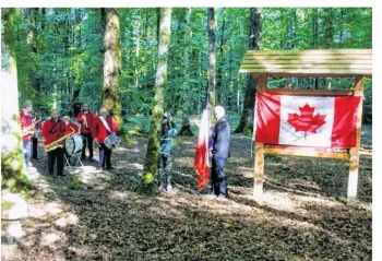  ??  ?? Un panneau aux couleurs du Canada présente l’épisode glorieux des milliers de Canadiens, le chêne honoré situé au fond à droite du panneau porte une ceinture verte.